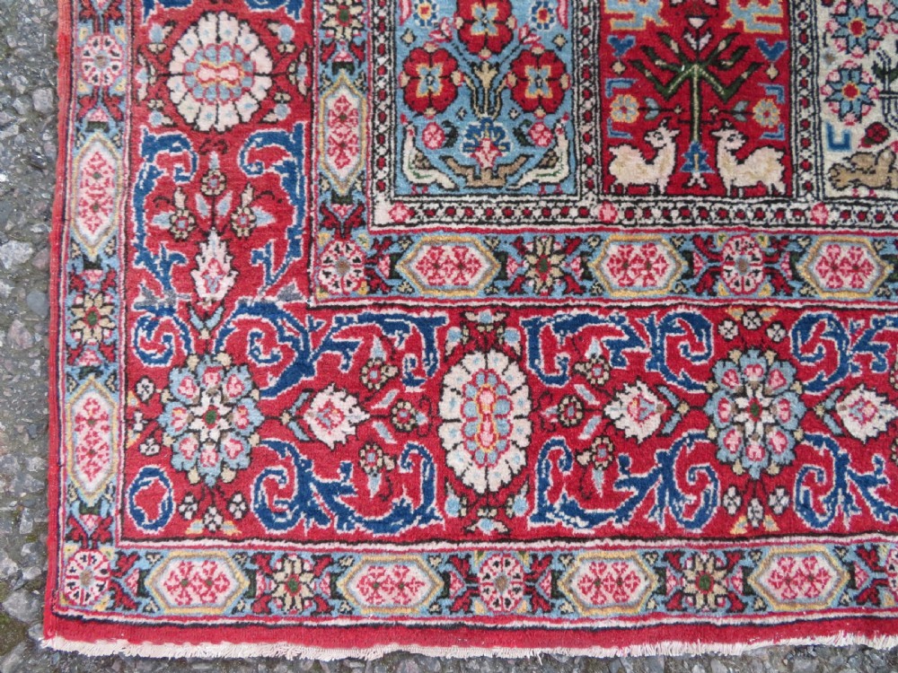A hand-knotted Persian Qum rug featuring a grid tile pattern filled with floral and animal motifs inside a detailed red border. View IX