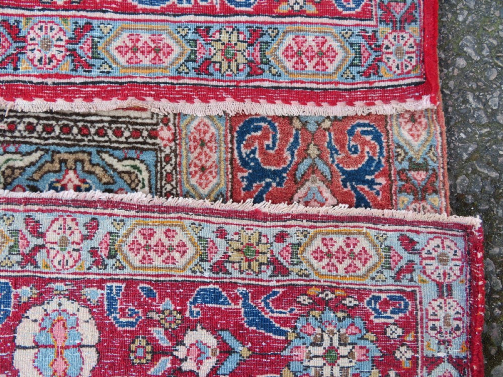 A hand-knotted Persian Qum rug featuring a grid tile pattern filled with floral and animal motifs inside a detailed red border. View XII