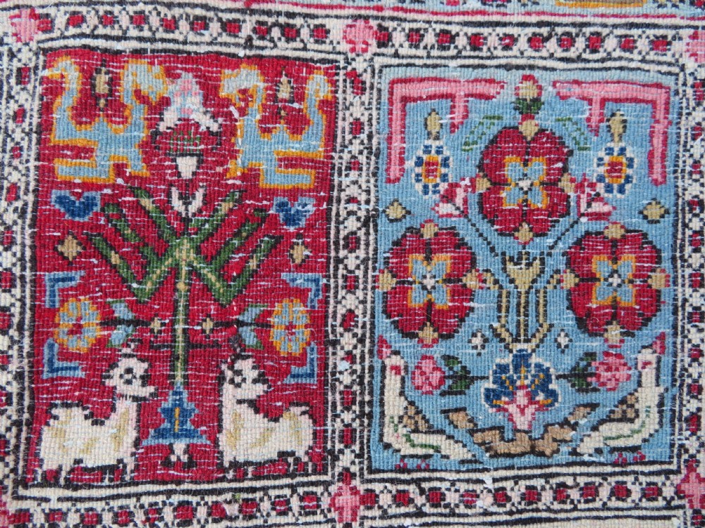 A hand-knotted Persian Qum rug featuring a grid tile pattern filled with floral and animal motifs inside a detailed red border. View XIII