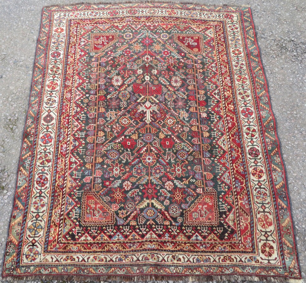 An antique hand-knotted Qashqai wool carpet with geometric bird, botanical motifs, and compound borders in deep red and navy blue. View II