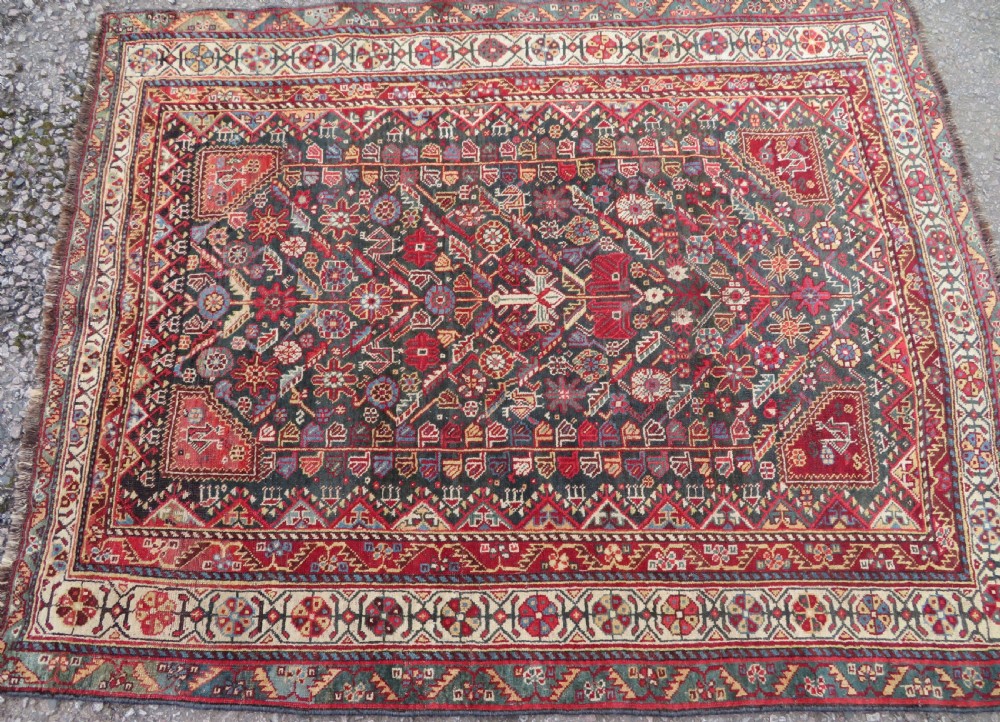 An antique hand-knotted Qashqai wool carpet with geometric bird, botanical motifs, and compound borders in deep red and navy blue. View III