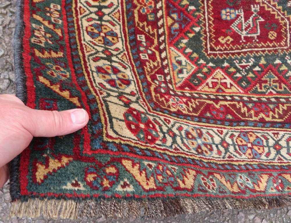 An antique hand-knotted Qashqai wool carpet with geometric bird, botanical motifs, and compound borders in deep red and navy blue. View VI