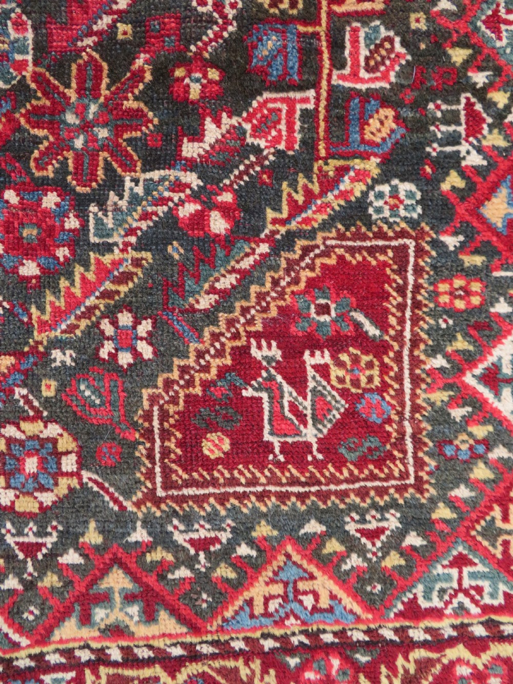 An antique hand-knotted Qashqai wool carpet with geometric bird, botanical motifs, and compound borders in deep red and navy blue. View VII