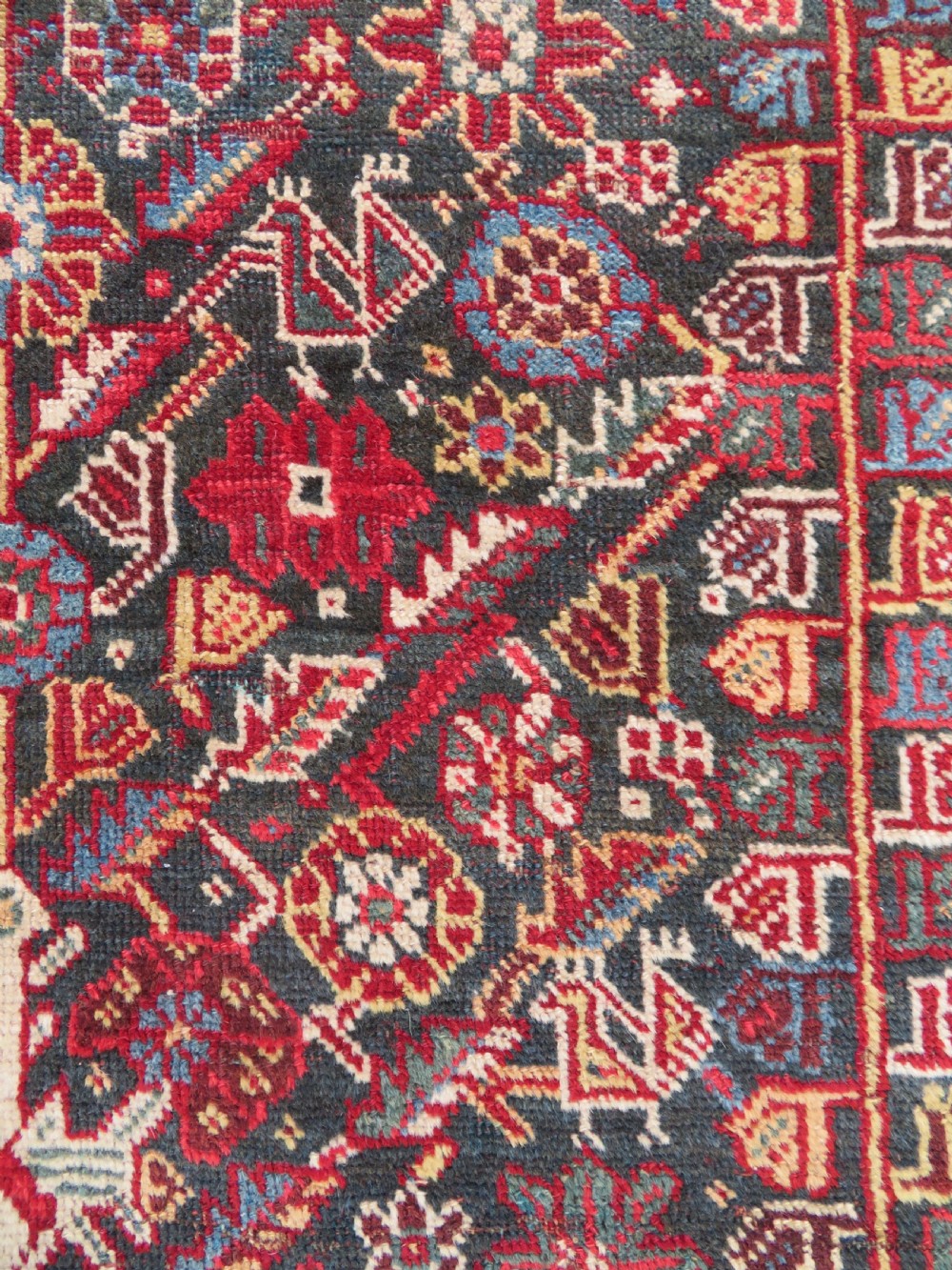 An antique hand-knotted Qashqai wool carpet with geometric bird, botanical motifs, and compound borders in deep red and navy blue. View VIII