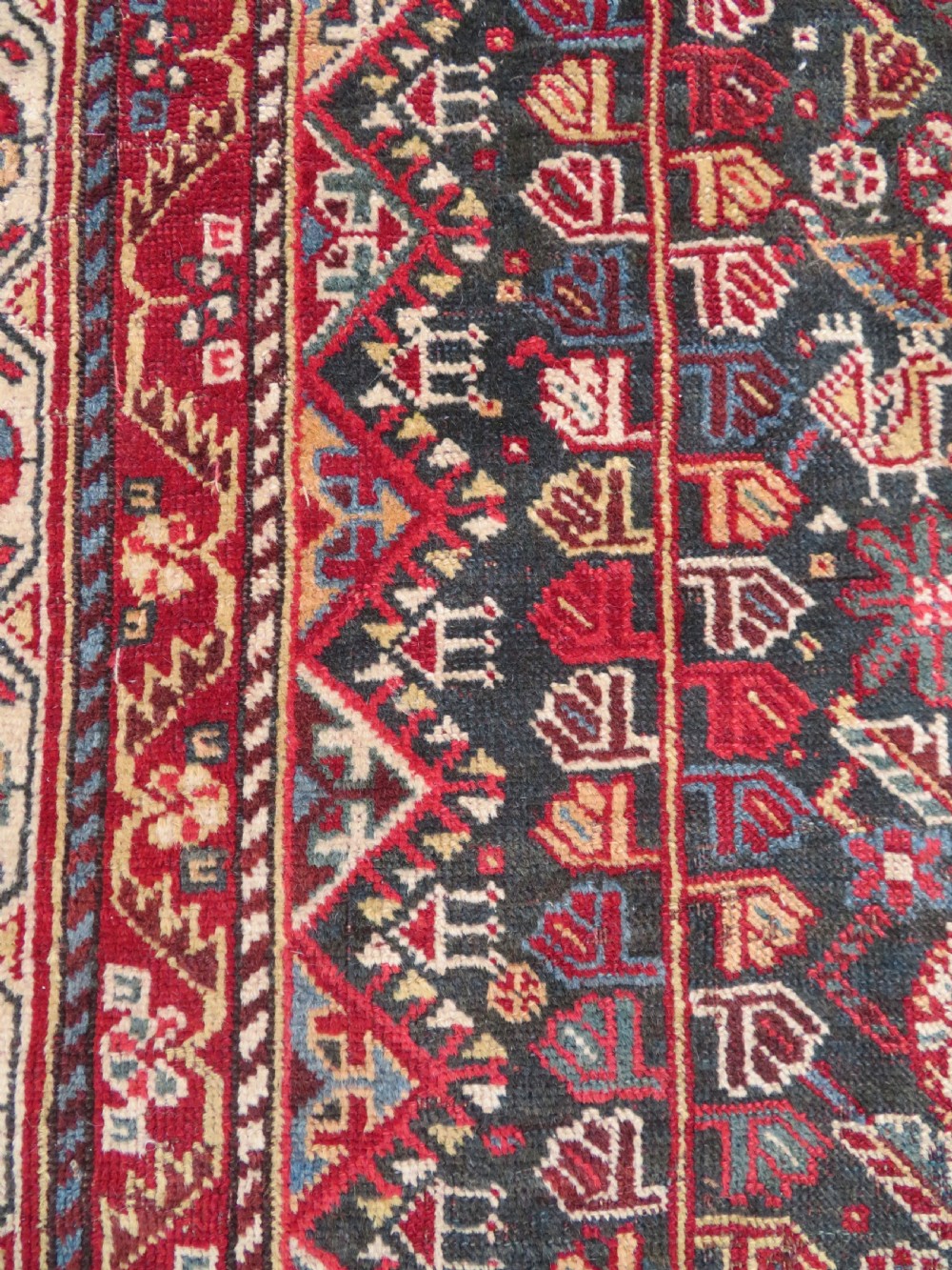 An antique hand-knotted Qashqai wool carpet with geometric bird, botanical motifs, and compound borders in deep red and navy blue. View XII