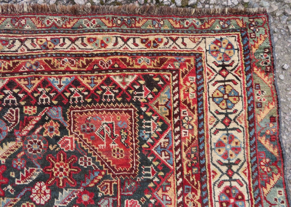 An antique hand-knotted Qashqai wool carpet with geometric bird, botanical motifs, and compound borders in deep red and navy blue. View XIII