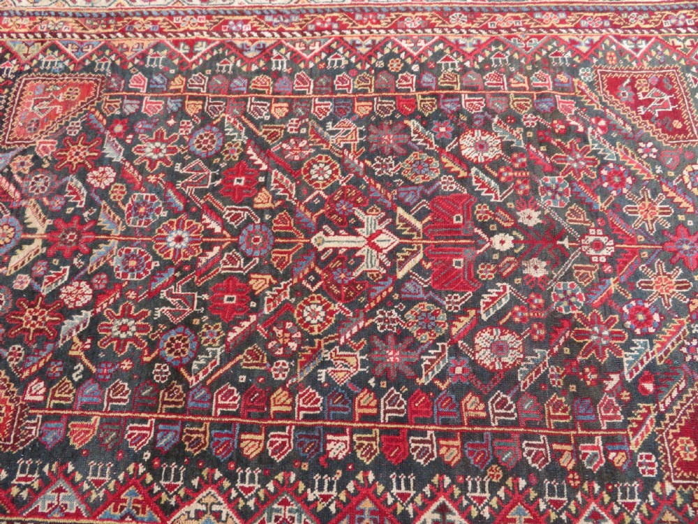 An antique hand-knotted Qashqai wool carpet with geometric bird, botanical motifs, and compound borders in deep red and navy blue. View XIV