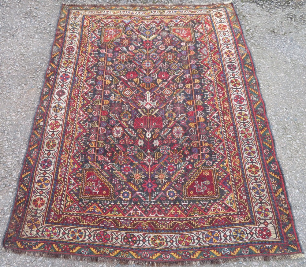 An antique hand-knotted Qashqai wool carpet with geometric bird, botanical motifs, and compound borders in deep red and navy blue. View XV