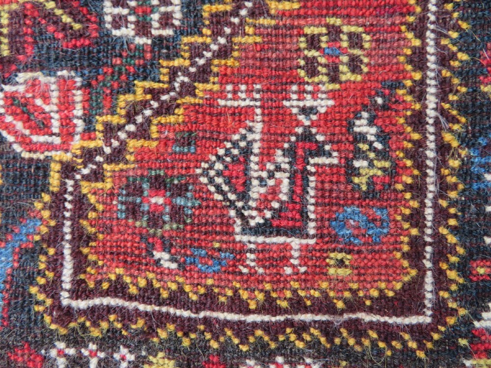 An antique hand-knotted Qashqai wool carpet with geometric bird, botanical motifs, and compound borders in deep red and navy blue. View XVIII