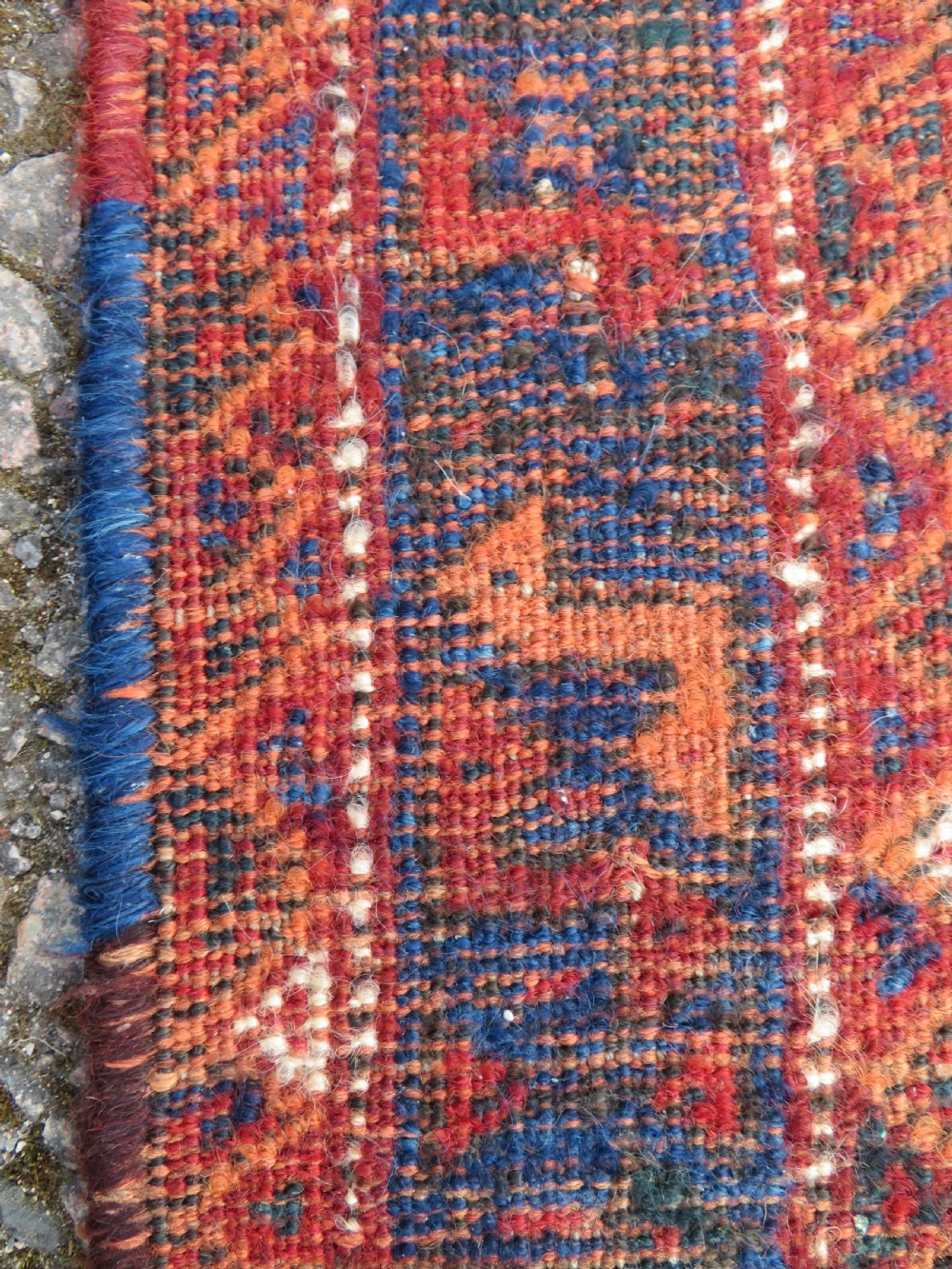 An antique square hand-knotted tribal wool rug panel featuring a central stepped geometric medallion in red, indigo blue, and ivory with fringed edges. View VIII