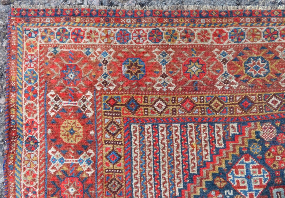 An antique hand-knotted Khamseh tribal carpet featuring multiple diamond medallions and geometric borders in navy blue, terracotta red, and cream wool. View XIII