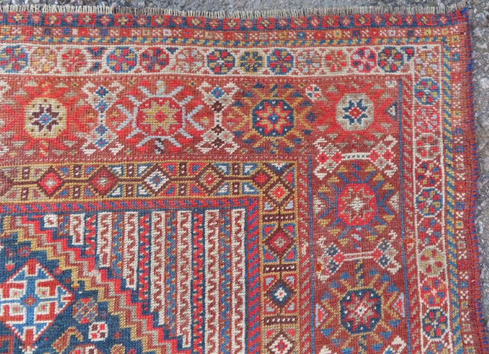 An antique hand-knotted Khamseh tribal carpet featuring multiple diamond medallions and geometric borders in navy blue, terracotta red, and cream wool. View XV