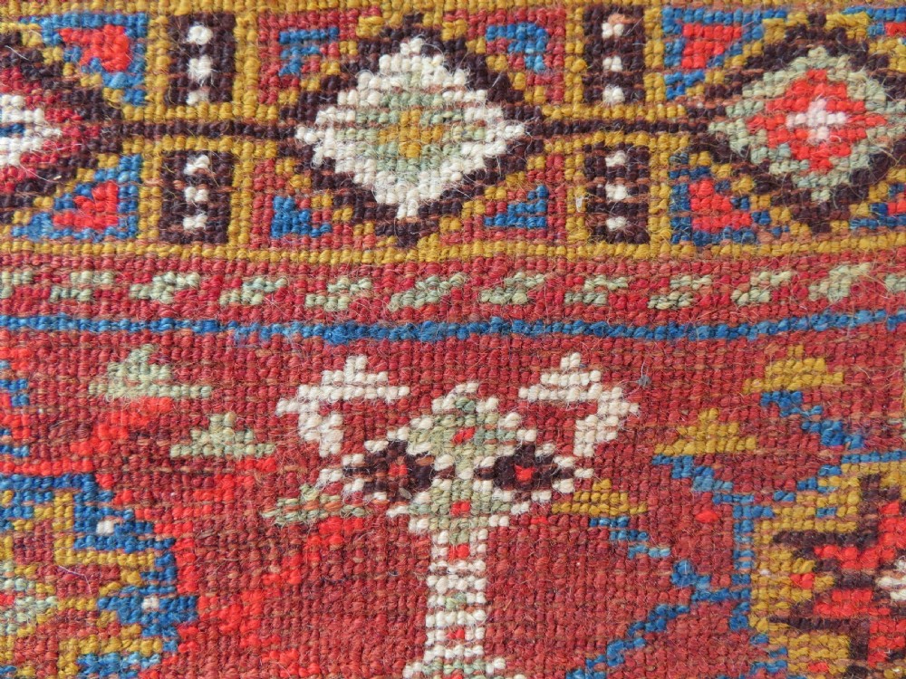 An antique hand-knotted Khamseh tribal carpet featuring multiple diamond medallions and geometric borders in navy blue, terracotta red, and cream wool. View XX