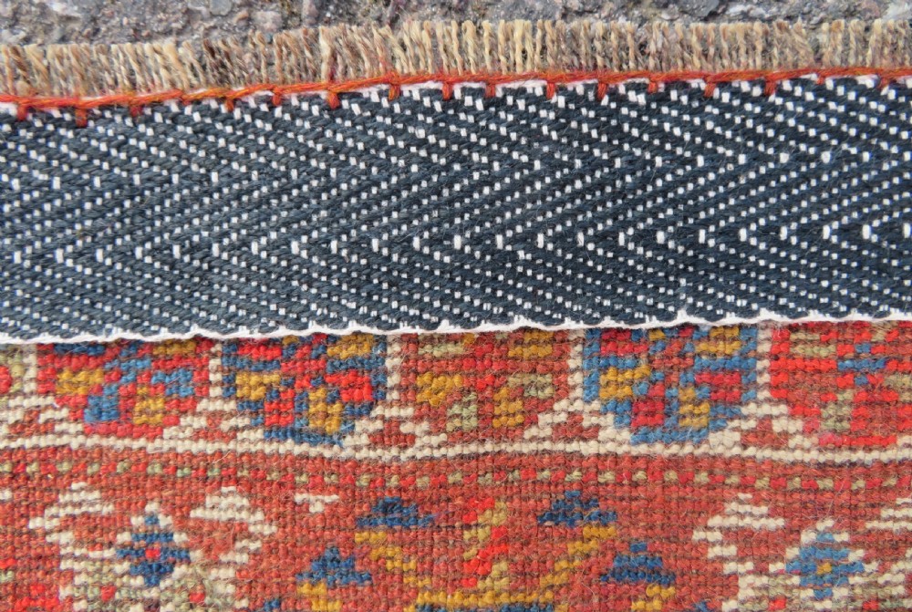 An antique hand-knotted Khamseh tribal carpet featuring multiple diamond medallions and geometric borders in navy blue, terracotta red, and cream wool. View XXI