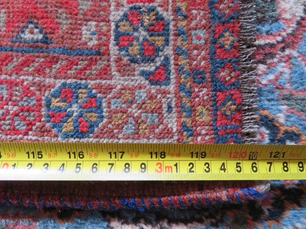An antique hand-knotted Khamseh tribal carpet featuring multiple diamond medallions and geometric borders in navy blue, terracotta red, and cream wool. View XXVI