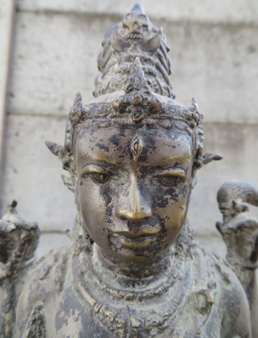A standing four-armed copper alloy figure of the Hindu deity Shiva on a lotus pedestal with an aged patina. View V