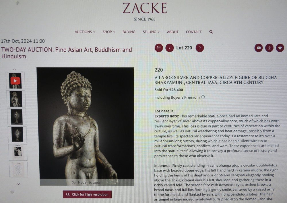 An ancient cast metal figure of Vishnu standing within a flame-edged aureole on a lotus base above a small figure. View XX