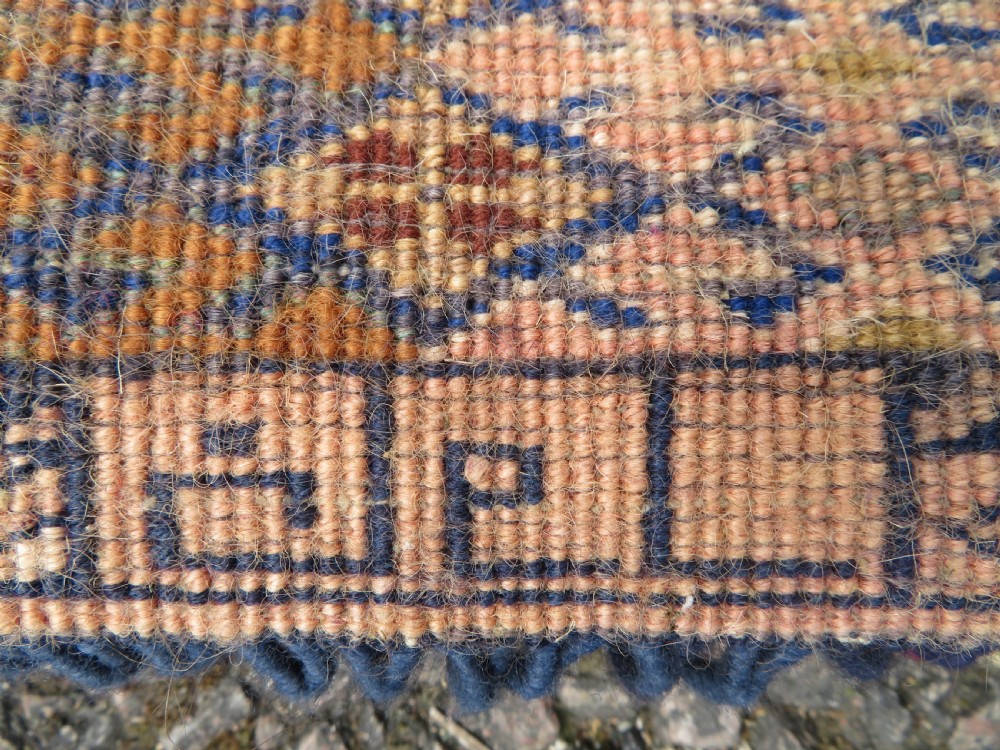 A handwoven arch-shaped Ersari kapunuk textile with geometric terracotta motifs and long decorative wool tassels dangling from the base. View XIII