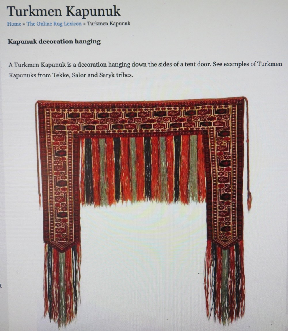 A handwoven arch-shaped Ersari kapunuk textile with geometric terracotta motifs and long decorative wool tassels dangling from the base. View XVIII