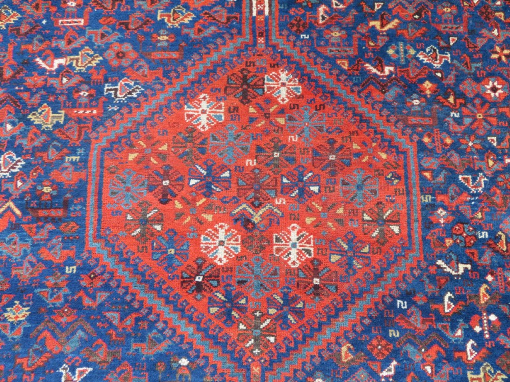 An antique Persian Khamseh carpet featuring three diamond-shaped central medallions and small bird motifs on a dark navy blue field with geometric borders. View VI