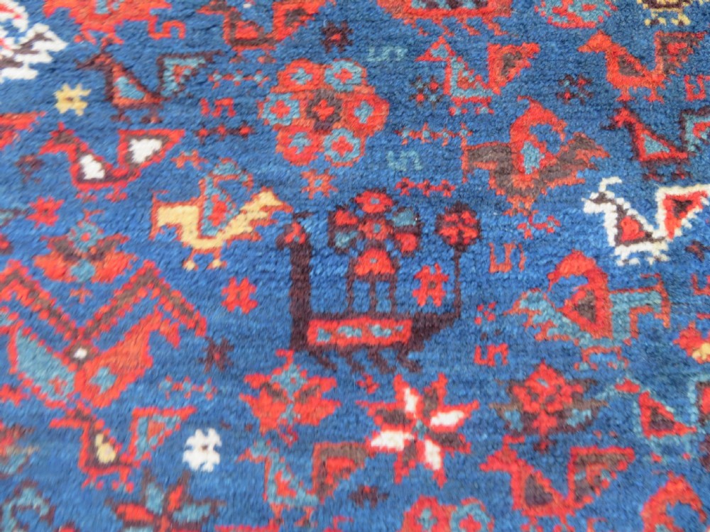 An antique Persian Khamseh carpet featuring three diamond-shaped central medallions and small bird motifs on a dark navy blue field with geometric borders. View VII