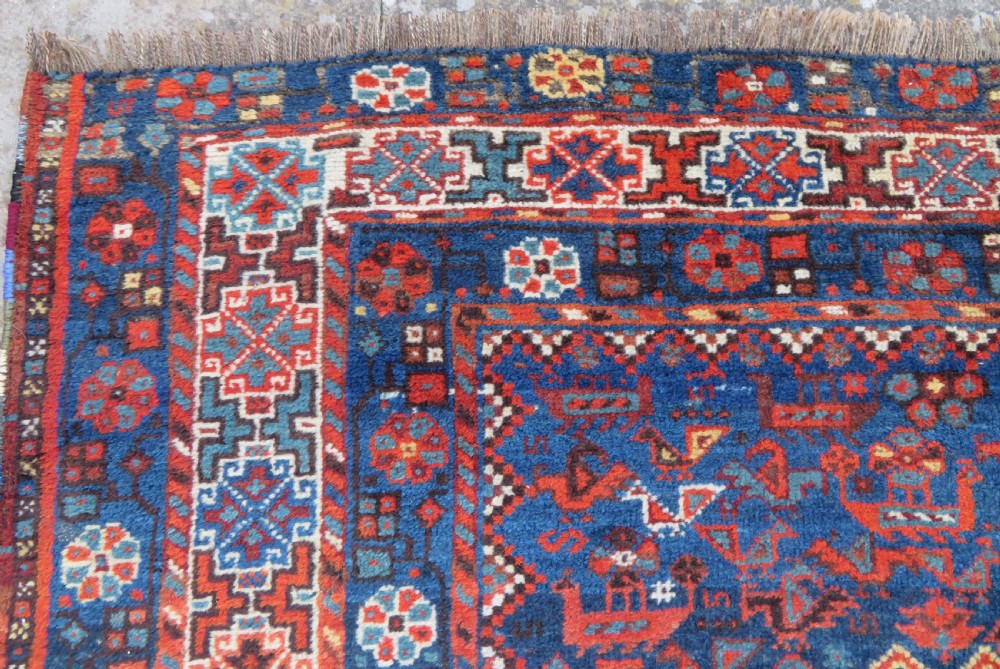 An antique Persian Khamseh carpet featuring three diamond-shaped central medallions and small bird motifs on a dark navy blue field with geometric borders. View X