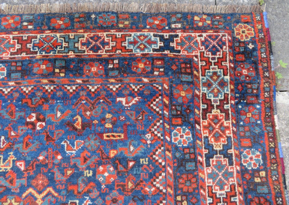 An antique Persian Khamseh carpet featuring three diamond-shaped central medallions and small bird motifs on a dark navy blue field with geometric borders. View XI