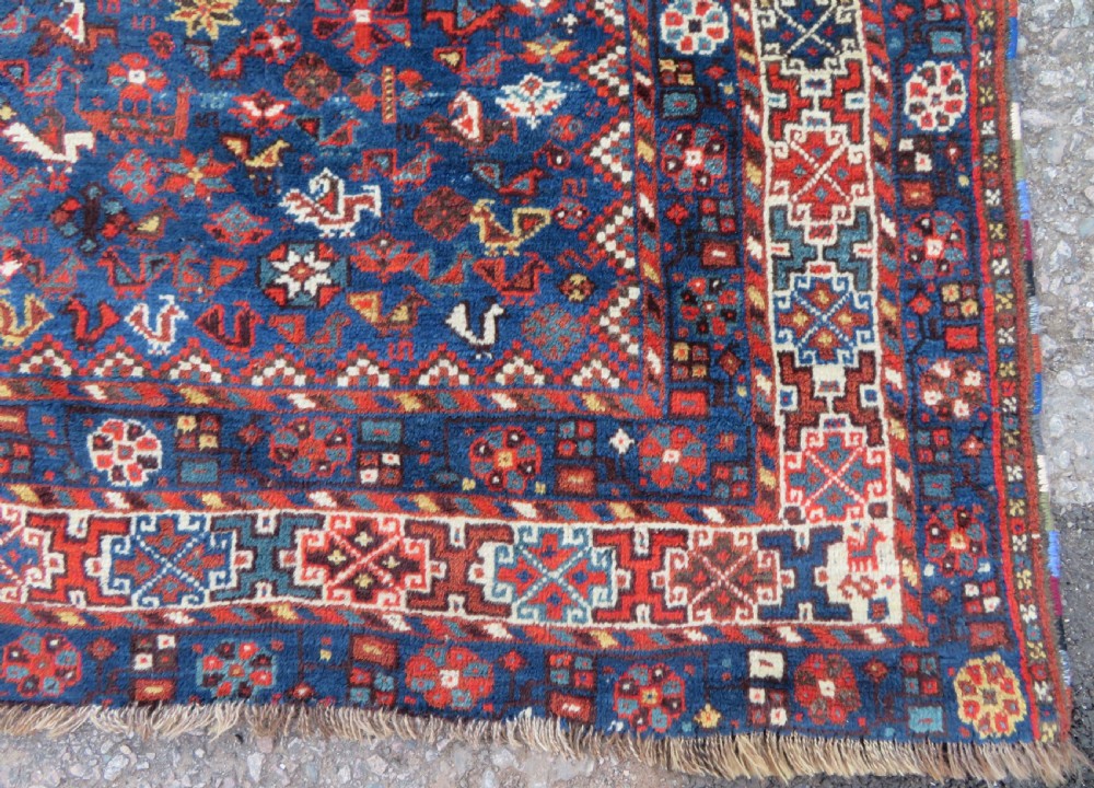 An antique Persian Khamseh carpet featuring three diamond-shaped central medallions and small bird motifs on a dark navy blue field with geometric borders. View XV