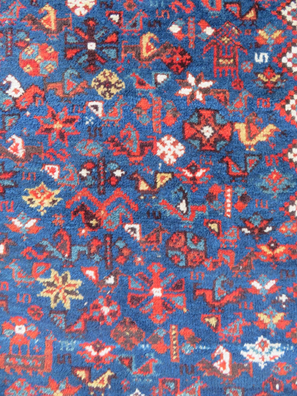 An antique Persian Khamseh carpet featuring three diamond-shaped central medallions and small bird motifs on a dark navy blue field with geometric borders. View XVII