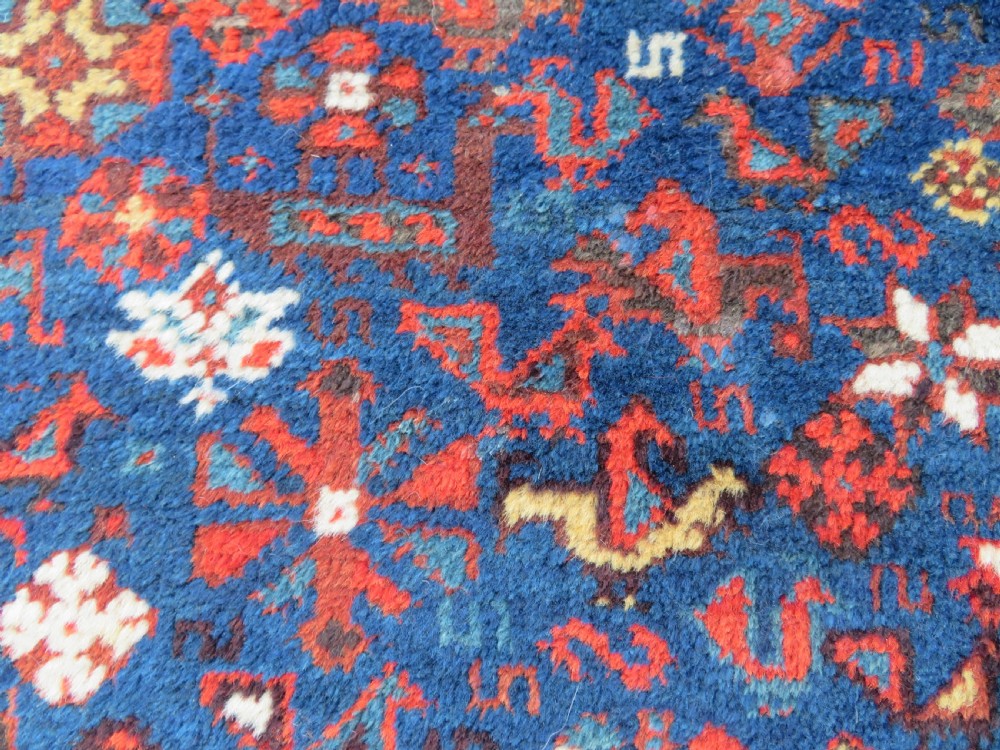An antique Persian Khamseh carpet featuring three diamond-shaped central medallions and small bird motifs on a dark navy blue field with geometric borders. View XVIII