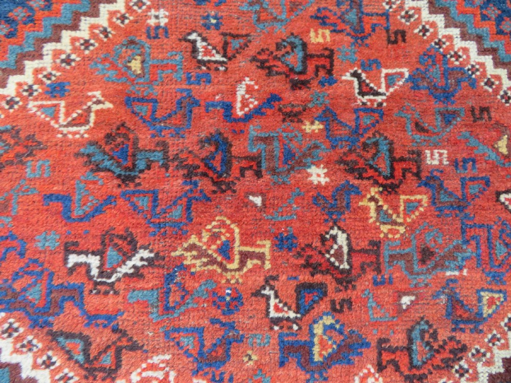 An antique Persian Khamseh carpet featuring three diamond-shaped central medallions and small bird motifs on a dark navy blue field with geometric borders. View XXI