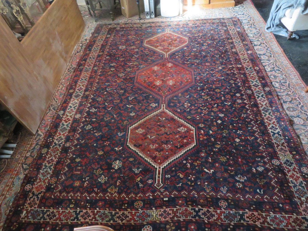 An antique Persian Khamseh carpet featuring three diamond-shaped central medallions and small bird motifs on a dark navy blue field with geometric borders. View XXVIII
