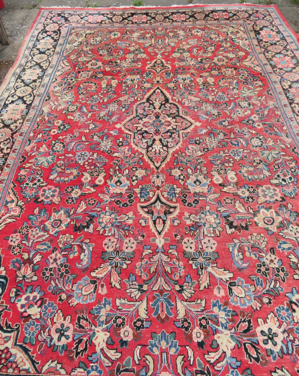 A large hand-knotted Sarouk Persian carpet featuring a dense red floral ground, central medallion, and elaborate dark borders. View III