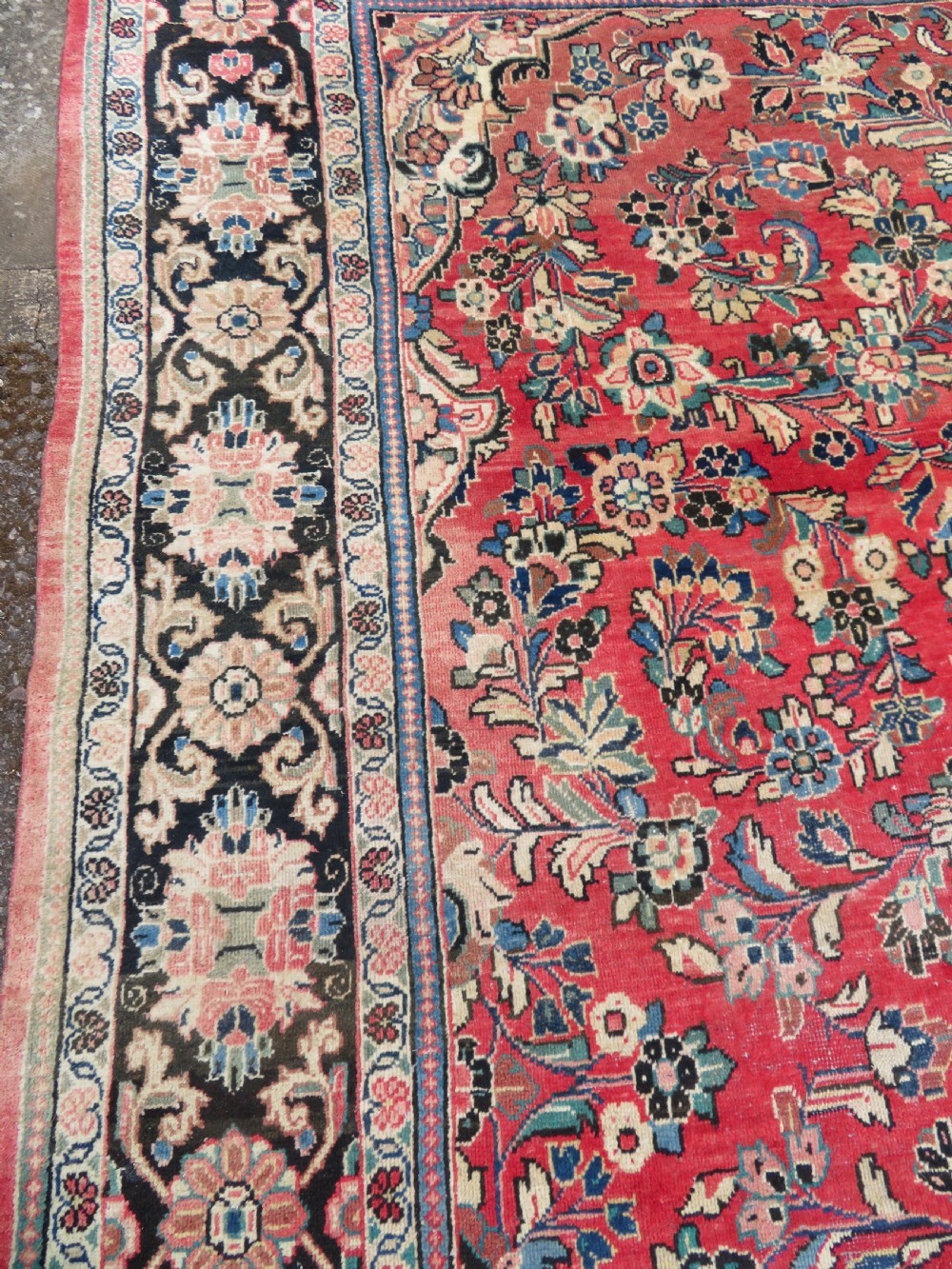 A large hand-knotted Sarouk Persian carpet featuring a dense red floral ground, central medallion, and elaborate dark borders. View XI