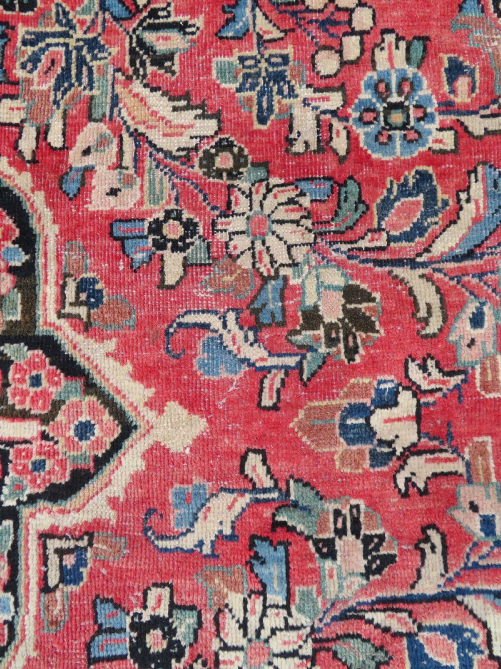 A large hand-knotted Sarouk Persian carpet featuring a dense red floral ground, central medallion, and elaborate dark borders. View XVI