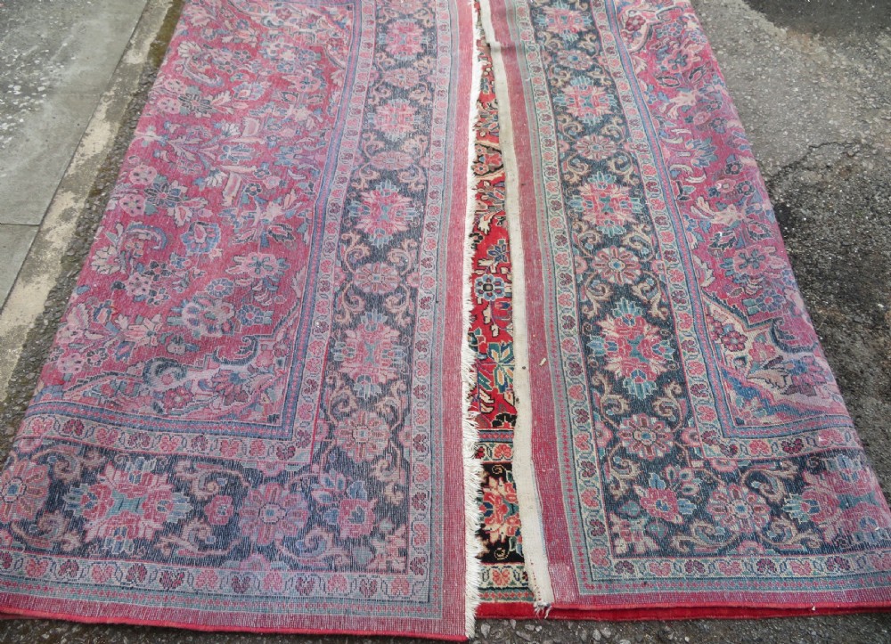 A large hand-knotted Sarouk Persian carpet featuring a dense red floral ground, central medallion, and elaborate dark borders. View XVII