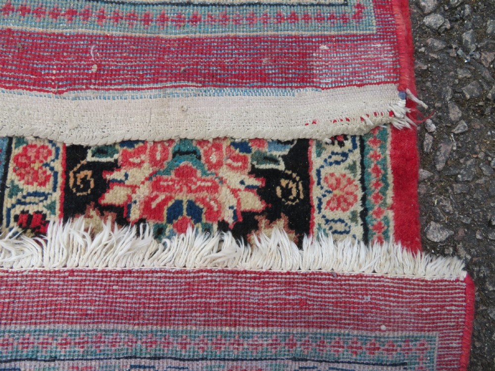 A large hand-knotted Sarouk Persian carpet featuring a dense red floral ground, central medallion, and elaborate dark borders. View XVIII