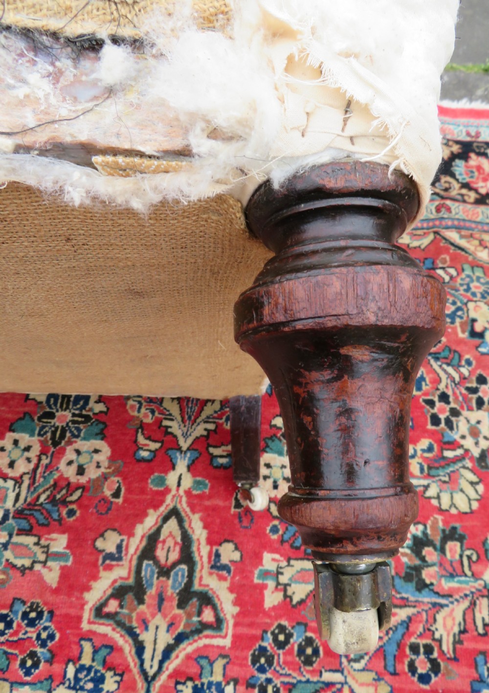 A Howard style low easy chair frame with exposed horsehair seat filling, cream calico back, and turned front wooden legs on ceramic castors. View VIII