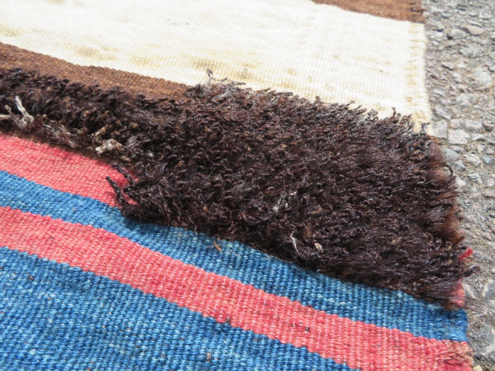 An antique flatweave Kurdish Tasheh wheat sack featuring vertical blue, red, cream, and brown stripes alongside a woven chevron motif. View II