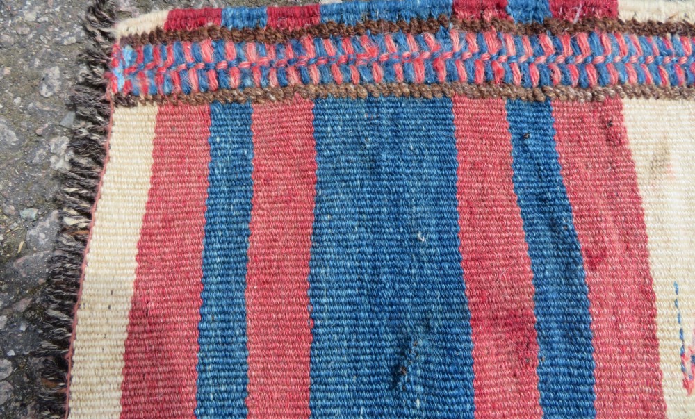 An antique flatweave Kurdish Tasheh wheat sack featuring vertical blue, red, cream, and brown stripes alongside a woven chevron motif. View IV