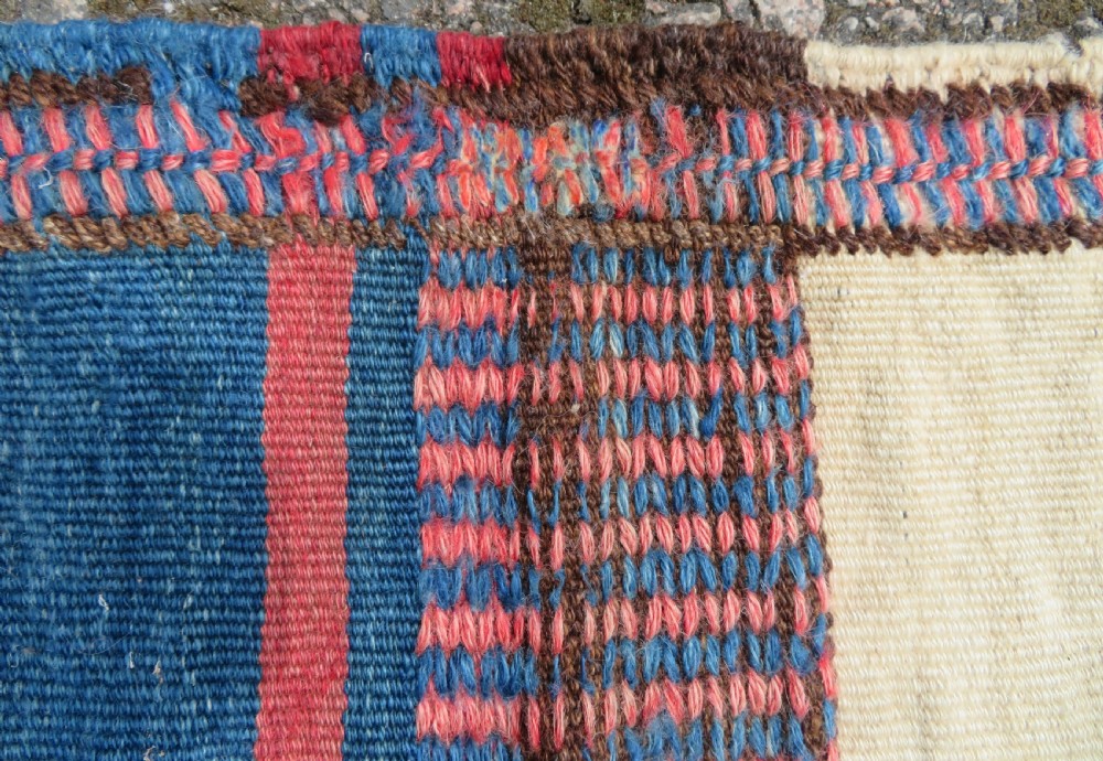 An antique flatweave Kurdish Tasheh wheat sack featuring vertical blue, red, cream, and brown stripes alongside a woven chevron motif. View V