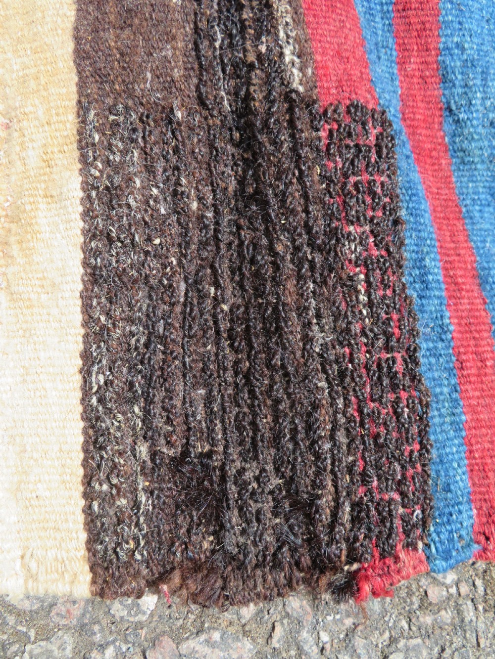 An antique flatweave Kurdish Tasheh wheat sack featuring vertical blue, red, cream, and brown stripes alongside a woven chevron motif. View X