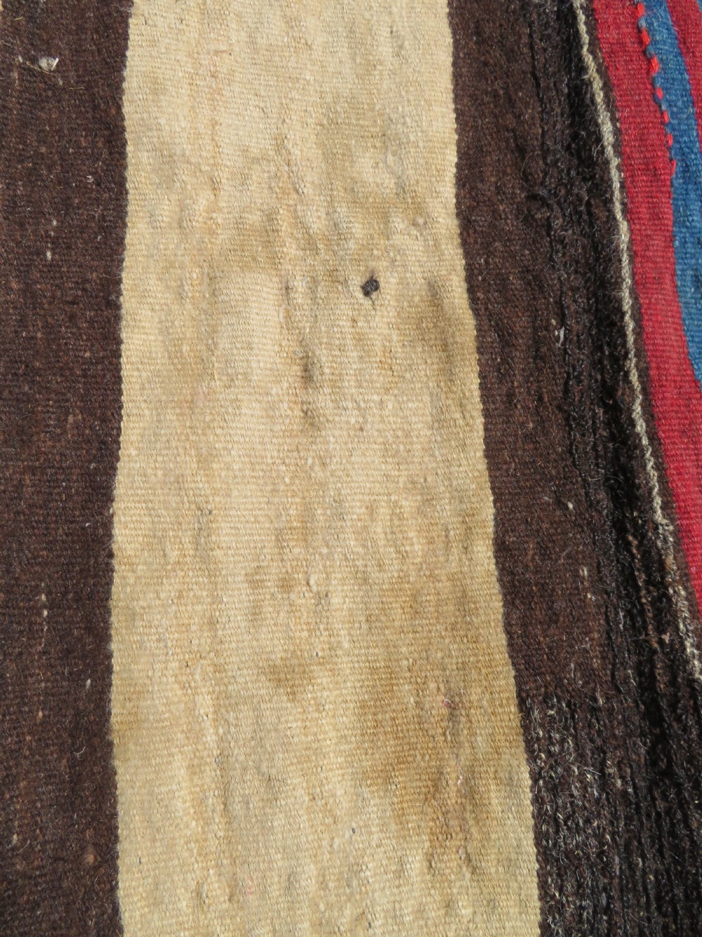An antique flatweave Kurdish Tasheh wheat sack featuring vertical blue, red, cream, and brown stripes alongside a woven chevron motif. View XII