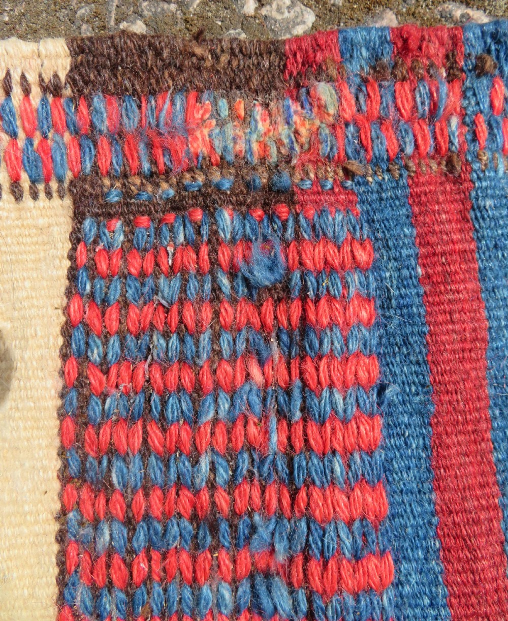 An antique flatweave Kurdish Tasheh wheat sack featuring vertical blue, red, cream, and brown stripes alongside a woven chevron motif. View XIV