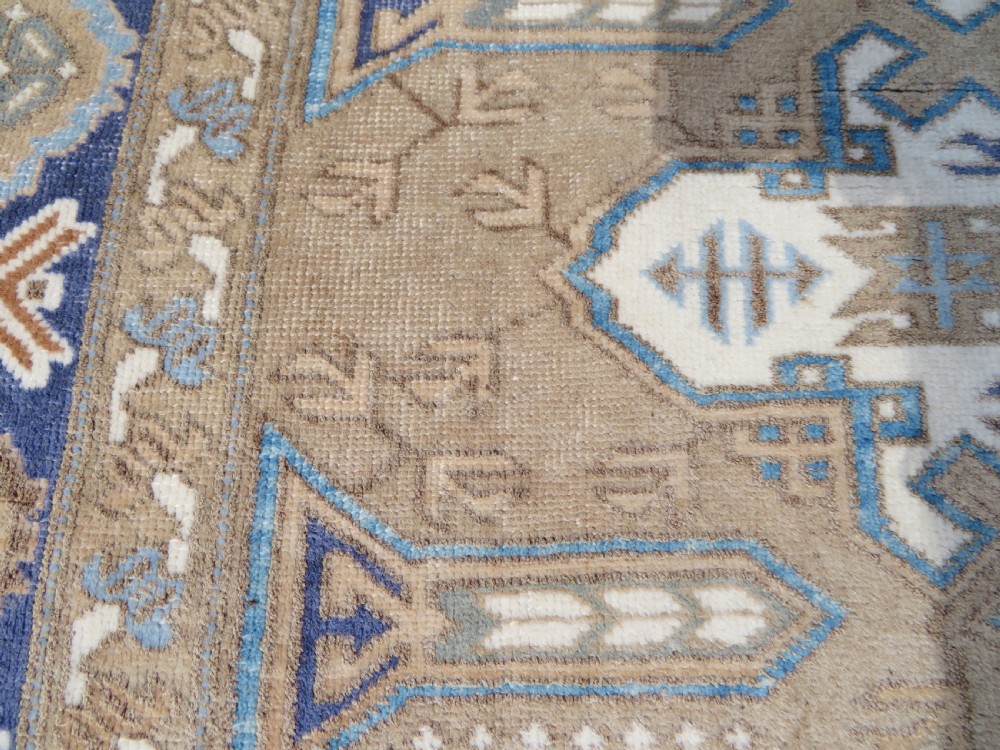 A hand-knotted North Persian Ardabil wool rug featuring three central geometric medallions in blue, cream, and beige on a neutral field with patterned borders. View IX