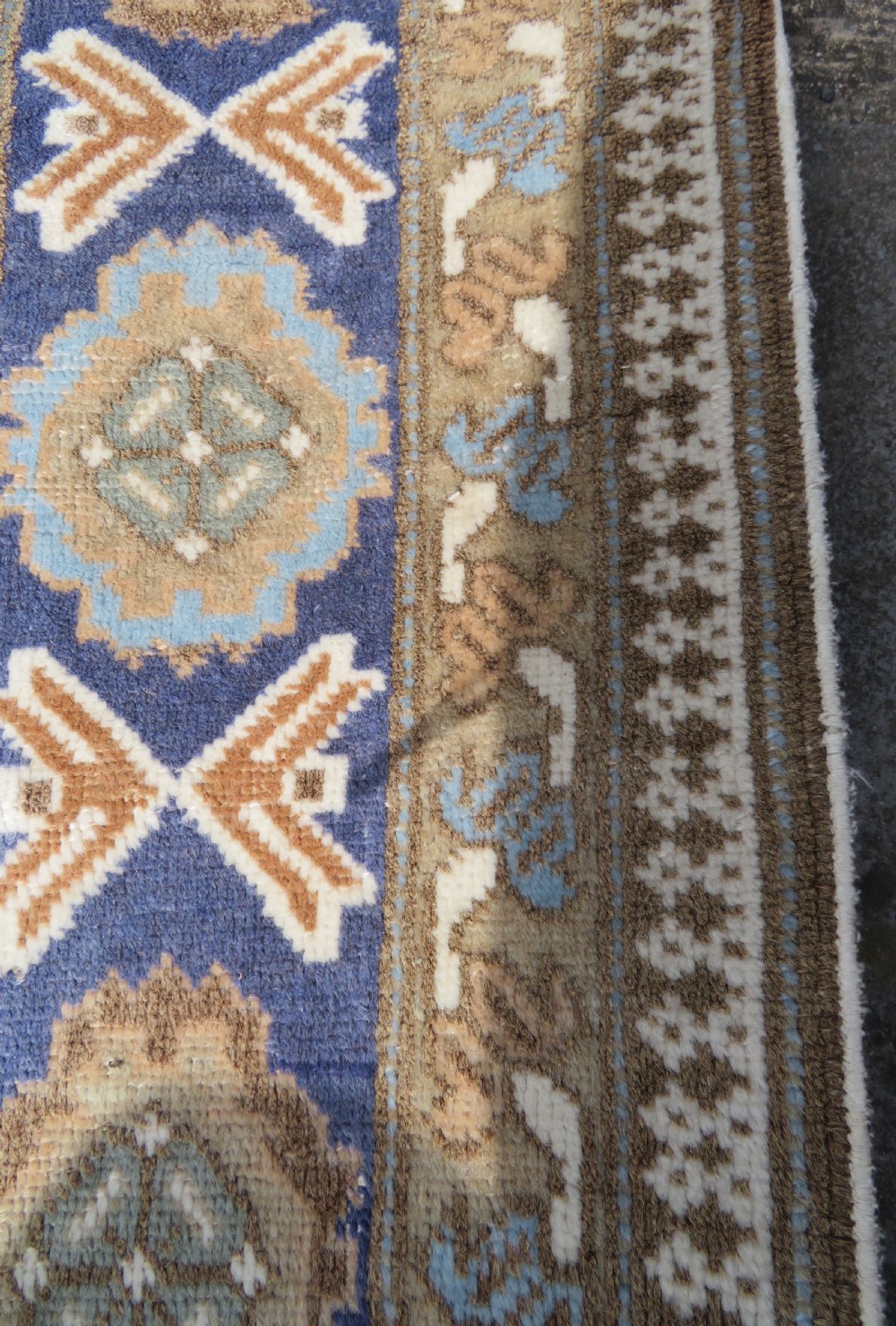 A hand-knotted North Persian Ardabil wool rug featuring three central geometric medallions in blue, cream, and beige on a neutral field with patterned borders. View X