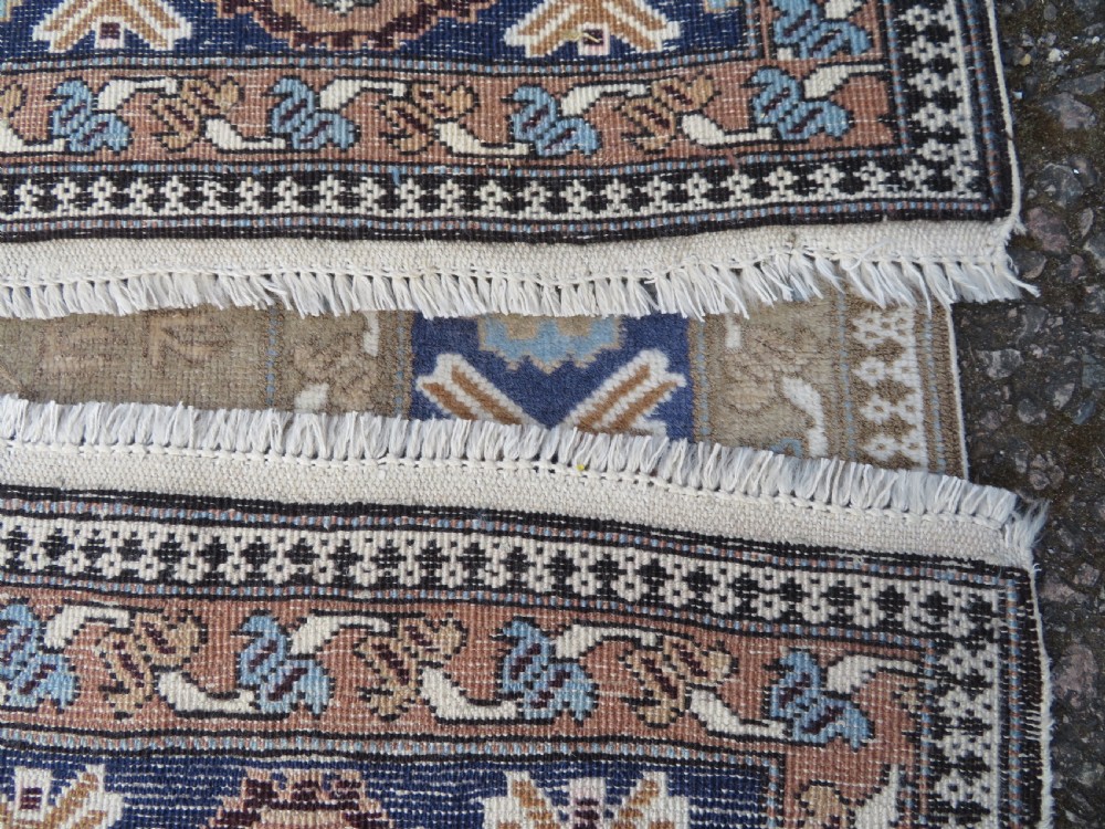 A hand-knotted North Persian Ardabil wool rug featuring three central geometric medallions in blue, cream, and beige on a neutral field with patterned borders. View XIV