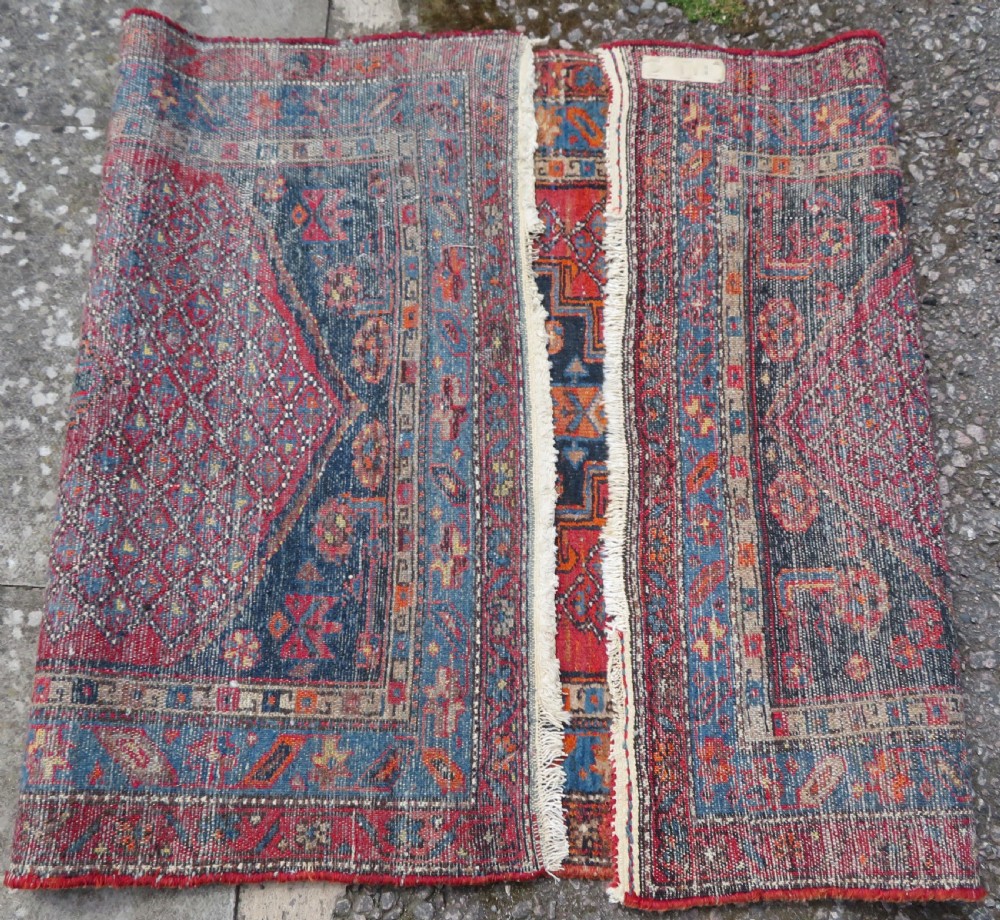 An antique hand-knotted Persian Sarab rug featuring a central dark blue geometric medallion on a red patterned field with light blue borders. View XIII