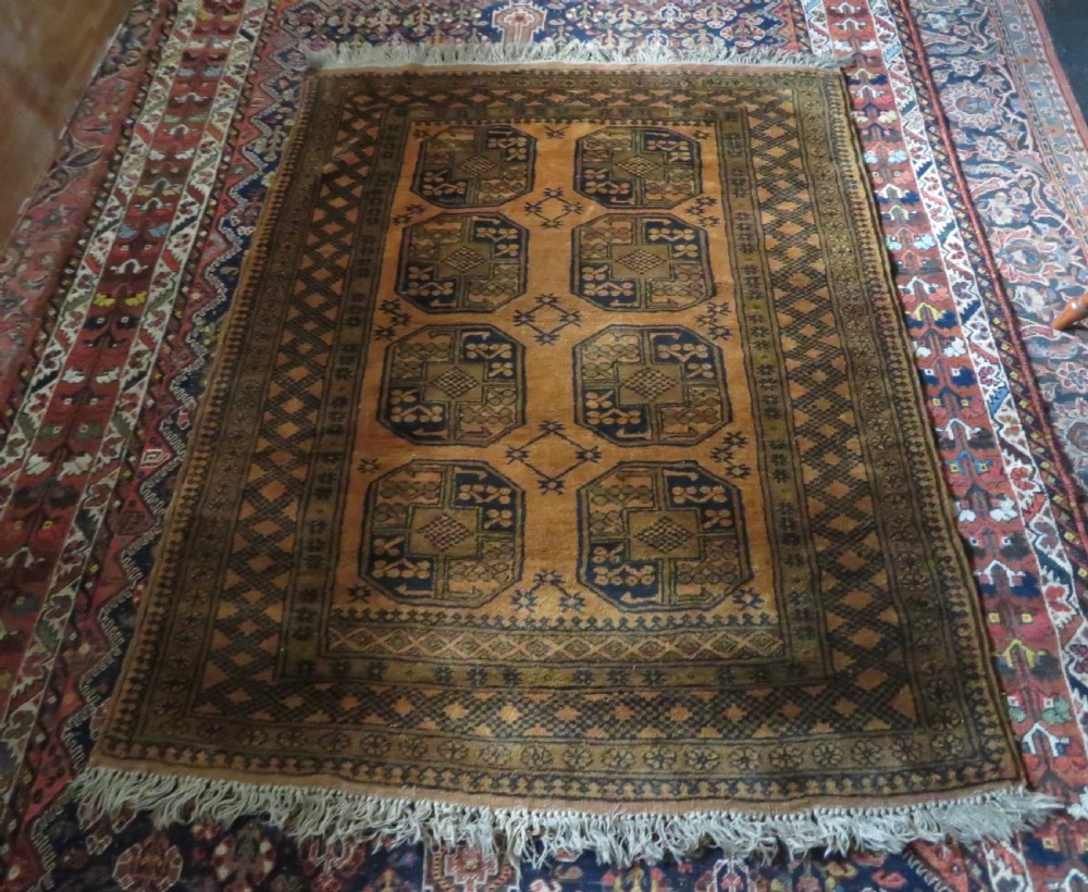 A rectangular hand-knotted Afghan wool rug with dark blue octagonal gul motifs set against a rich gold field with geometric borders. View XIV