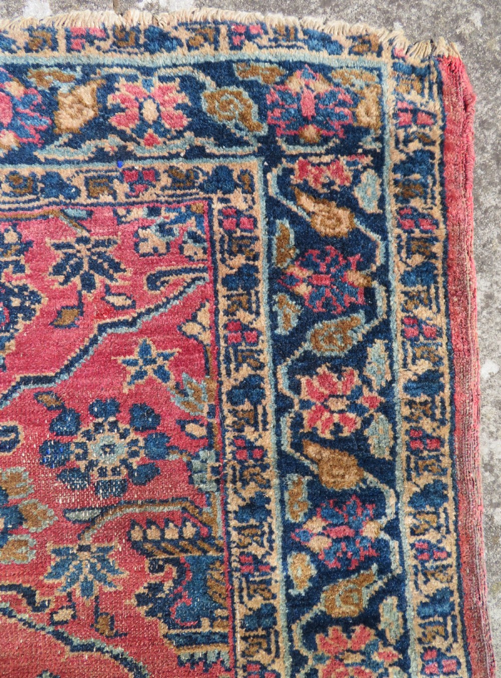 An antique West Persian Sarouk hand-knotted wool rug featuring a rose pink field adorned with floral vase motifs and a navy blue floral border. View IX